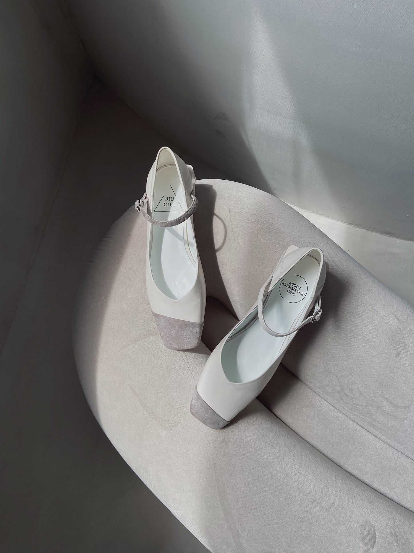 White leather square-toe Mary Jane heels with asymmetric ankle straps and light grey suede toe caps