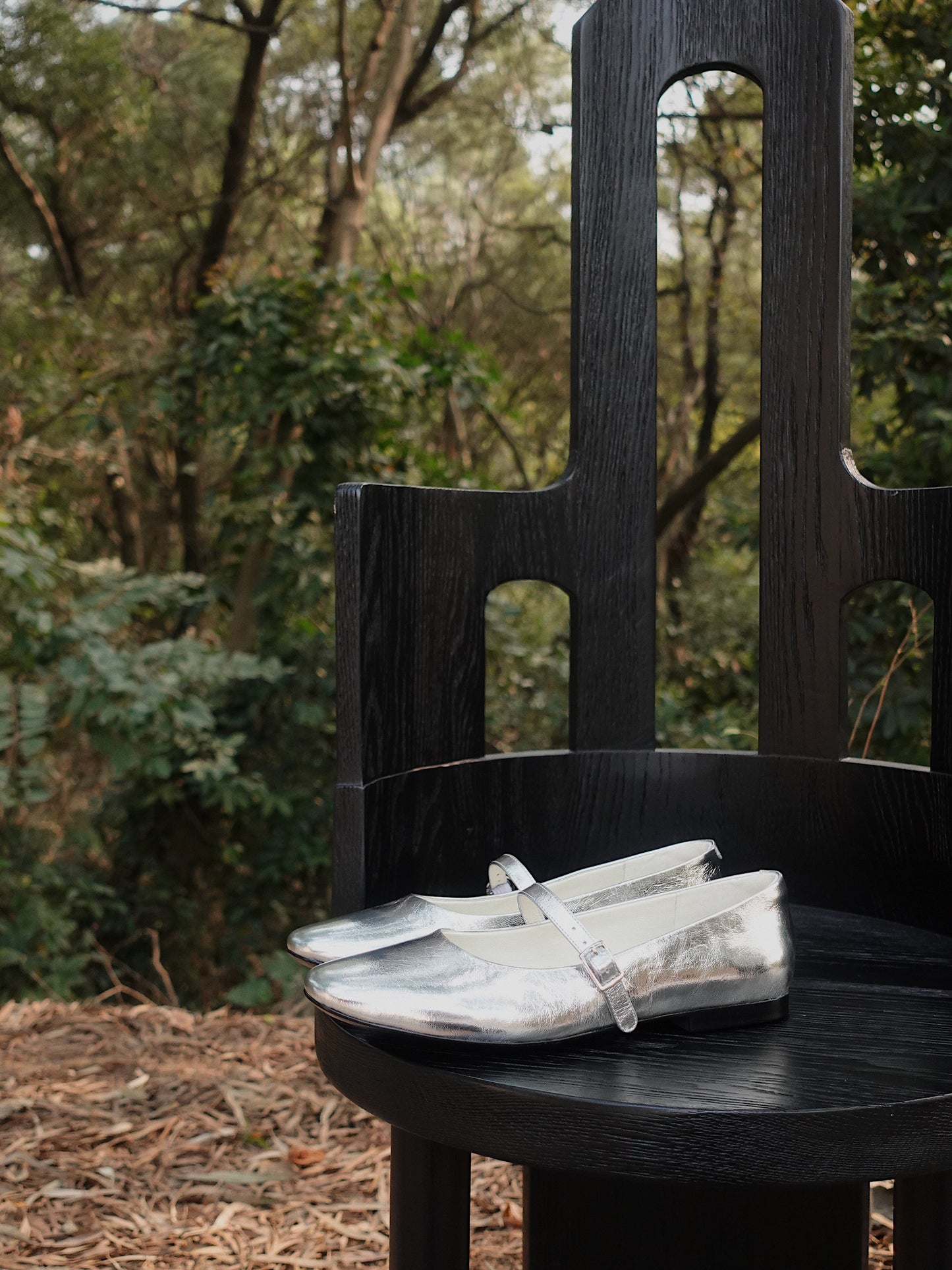 Elegant Silver Mary Jane leather flats for women, placed on a black chair in the natural