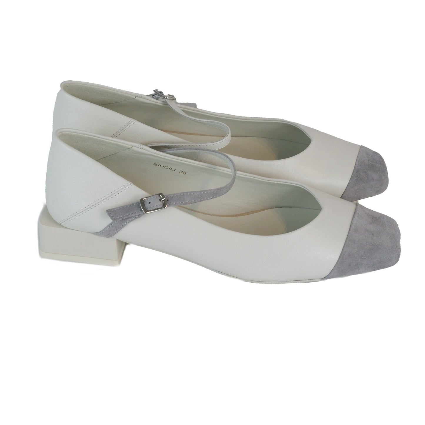 Side view of white leather square-toe Mary Jane heels with asymmetric ankle straps and light grey suede toe caps