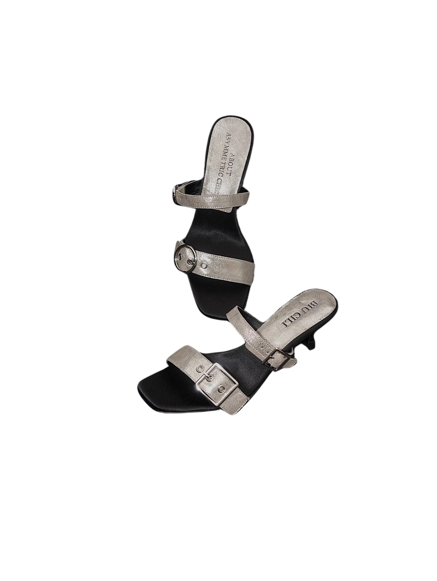 A pair of mid heel sandals with two thick leather straps and shiny silver buckle - top and side view - placing in front of a white background
