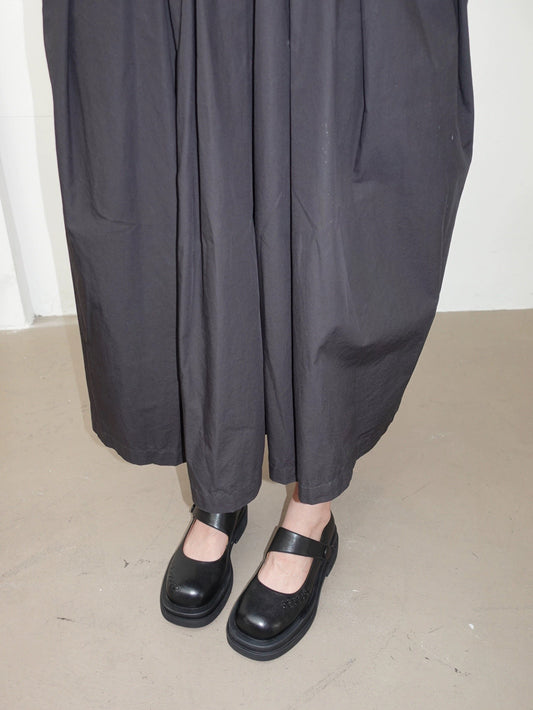 Women wearing a pair of matte finish black platform Mary Jane shoes with wide straps and low block heels