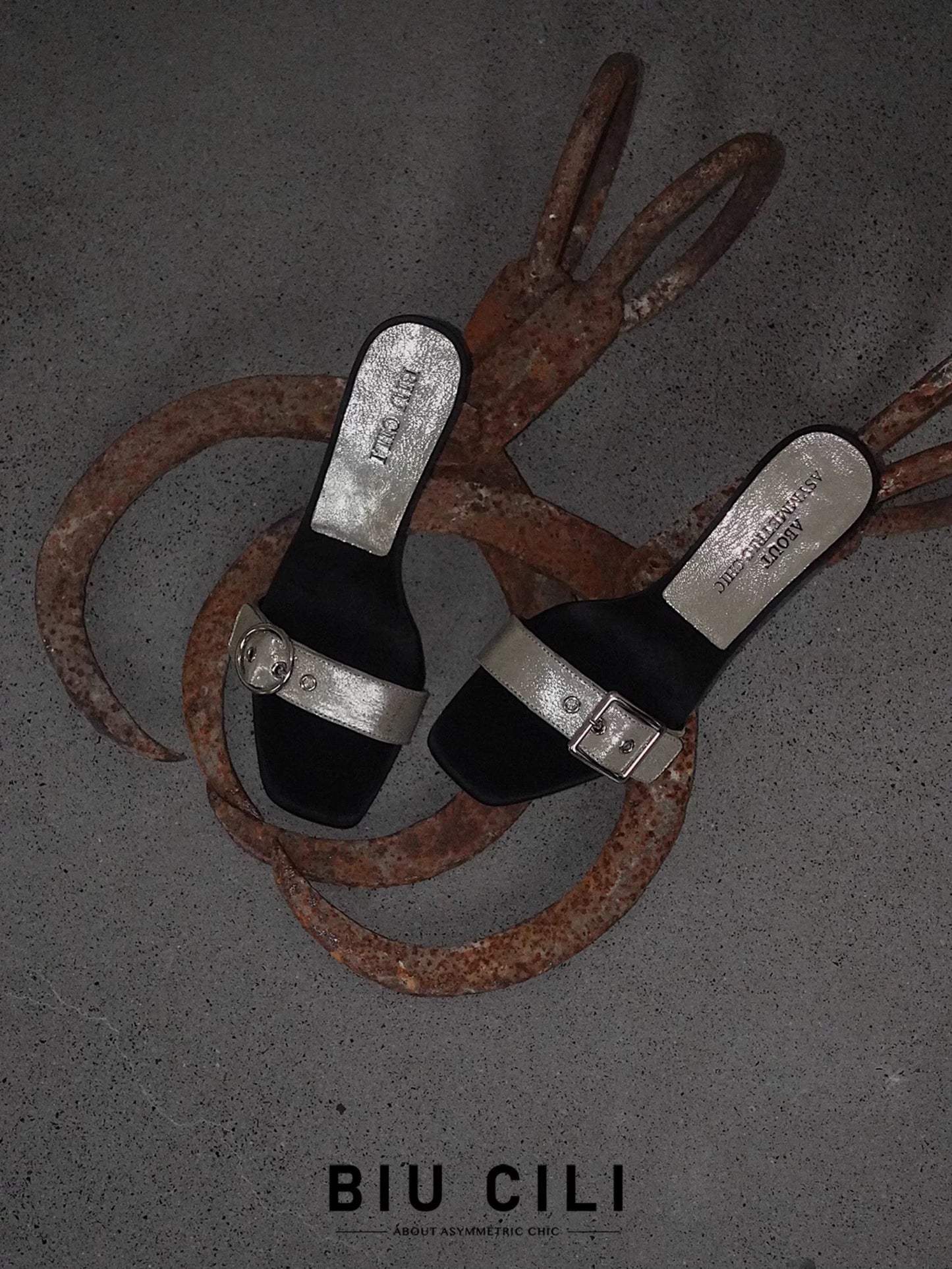 A pair of women's summer mid heel sandals with asymmetrical silver buckle – top view