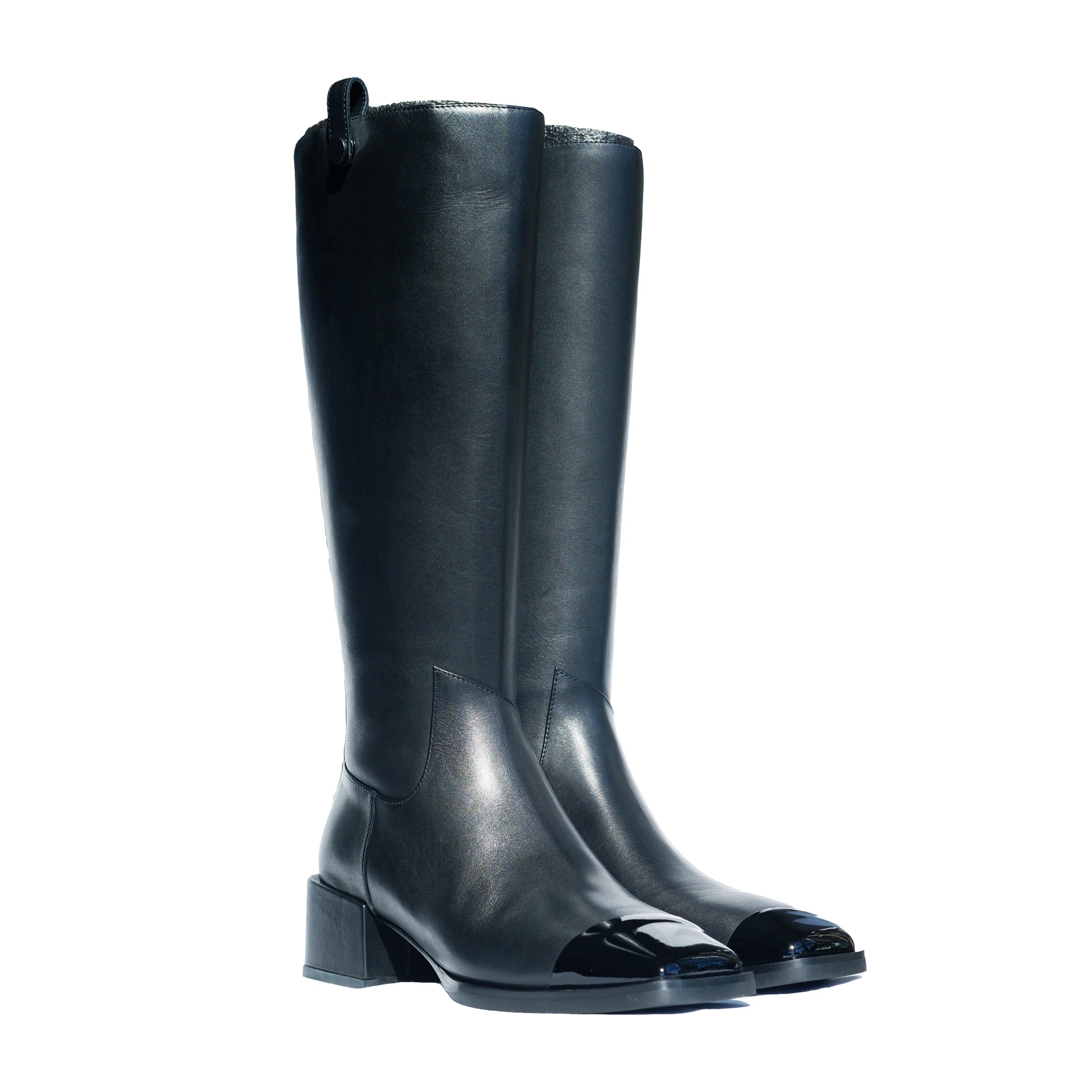 A pair of black calfskin leather knee-high boots with a low block heel and asymmetric details at toe on a white background