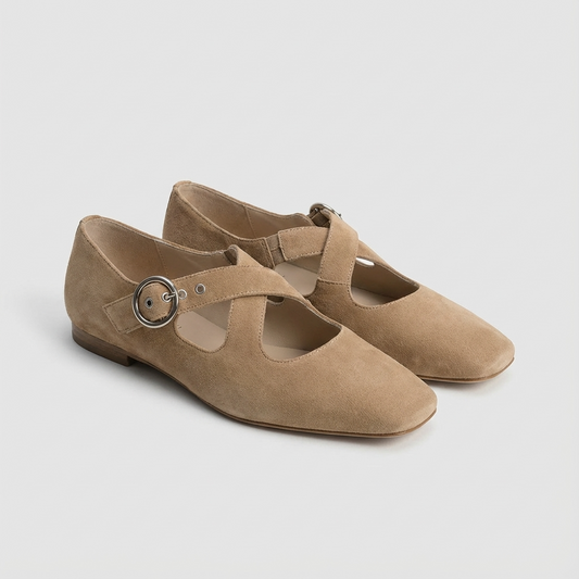 Pair of khaki suede shoes with a round buckle on a light gray background