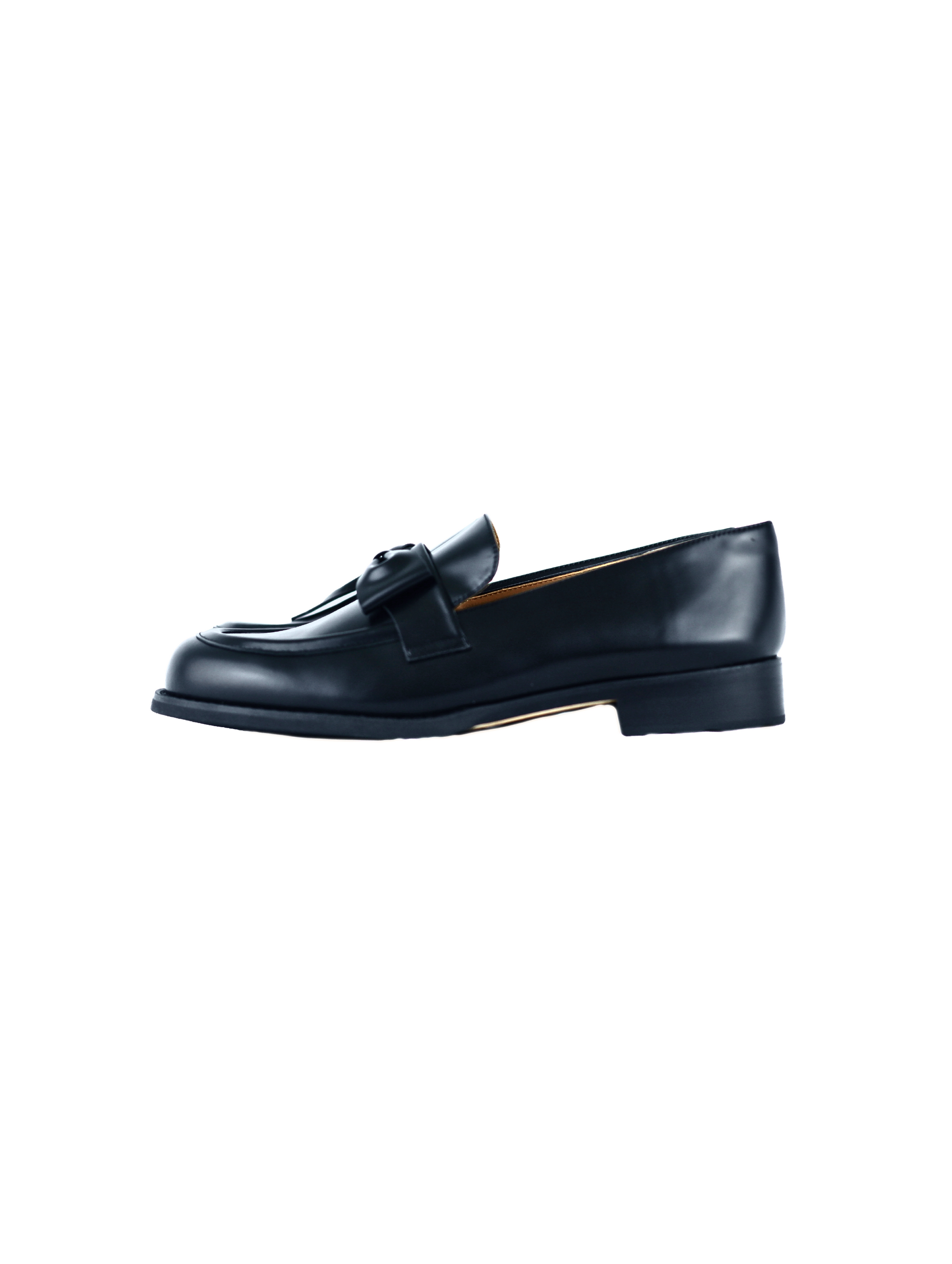 Black leather loafers for women featuring asymmetric tie and bow details, crafted in matte calfskin with low heel and soft structure, shown on white background.