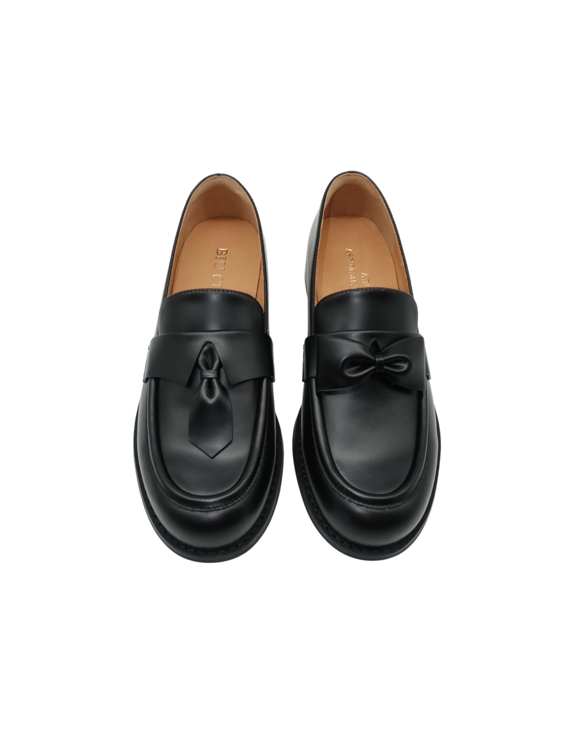 Black leather loafers for women featuring asymmetric tie and bow details, crafted in matte calfskin with low heel and soft structure, shown on white background.