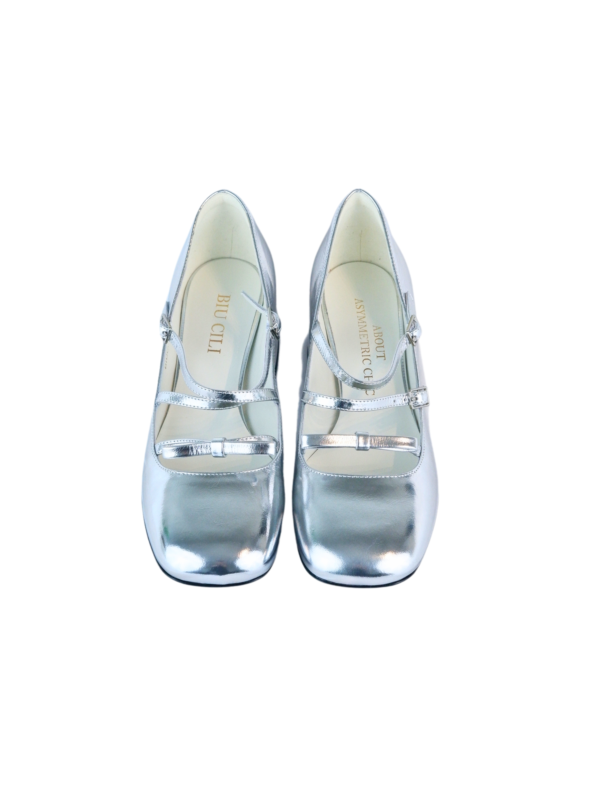 Metallic silver Mary Jane heels with triple asymmetric straps and block heel.
