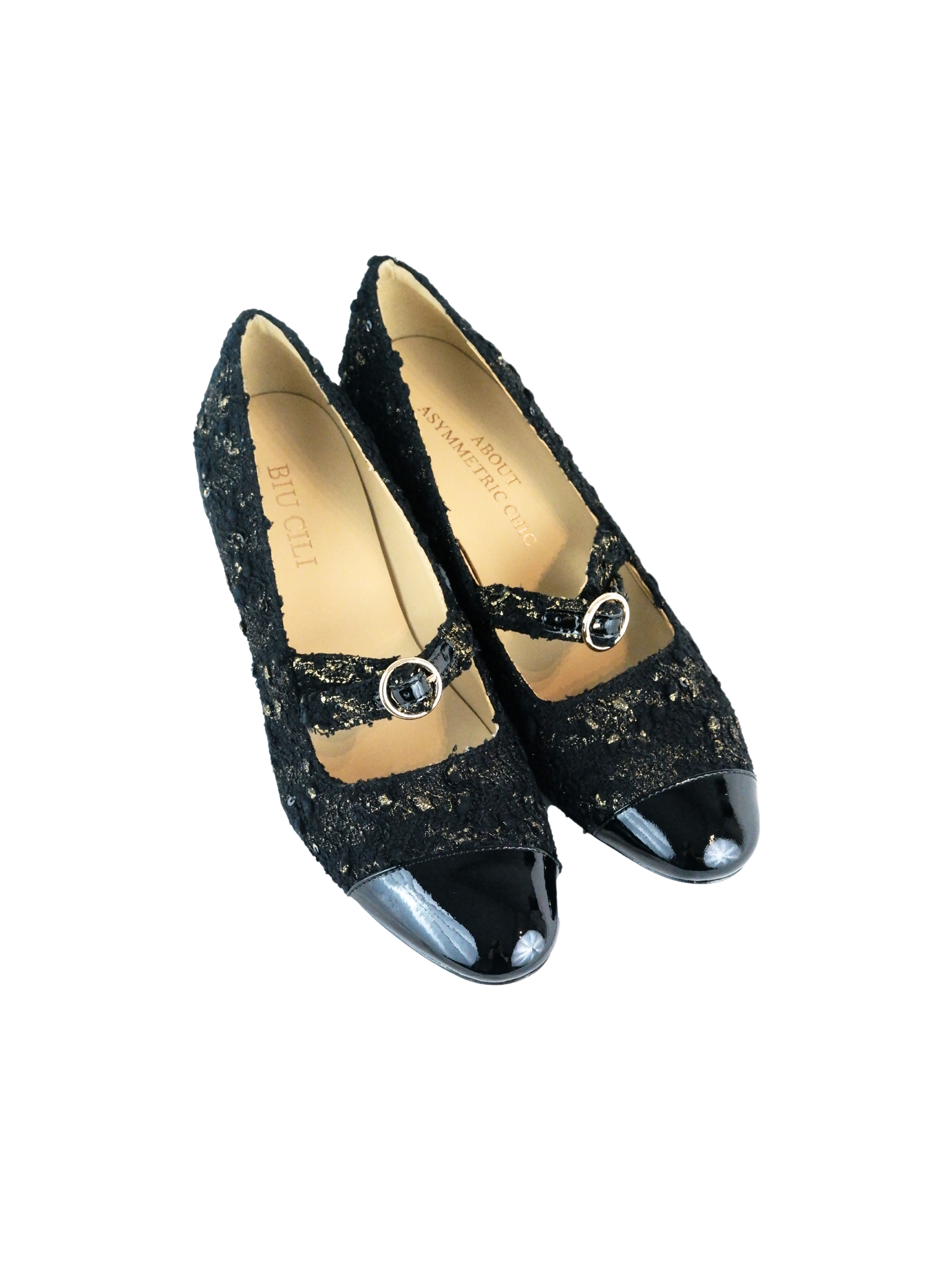 Elegant black Mary Janes featuring patent leather tweed design with asymmetric details and mid block heel