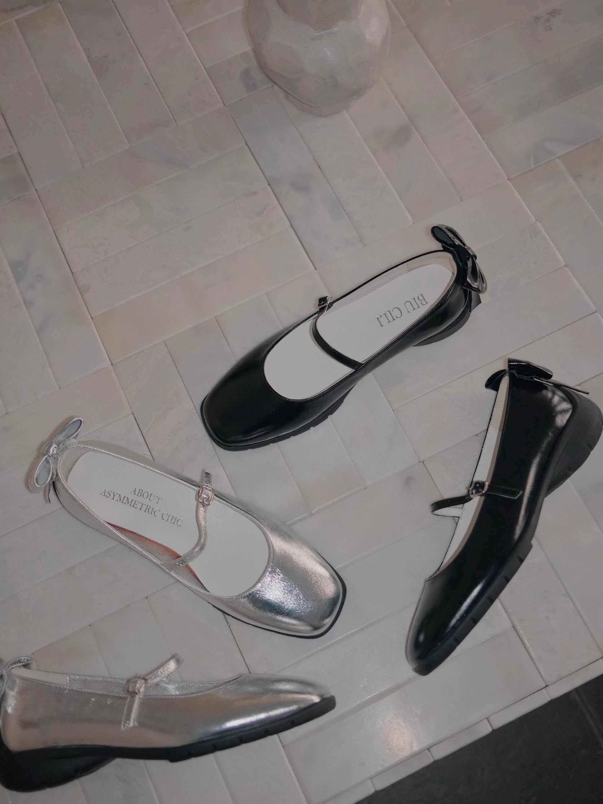 Sporty Mary Jane shoes in shimmering silver and black with back bow scattering across the floor