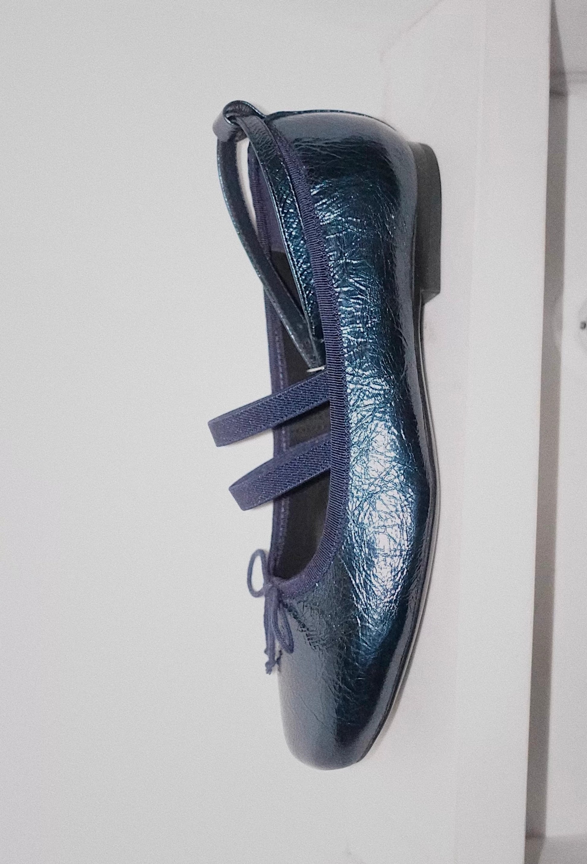 Side view of navy metallic leather Mary Jane ballet flats with asymmetrical cross straps