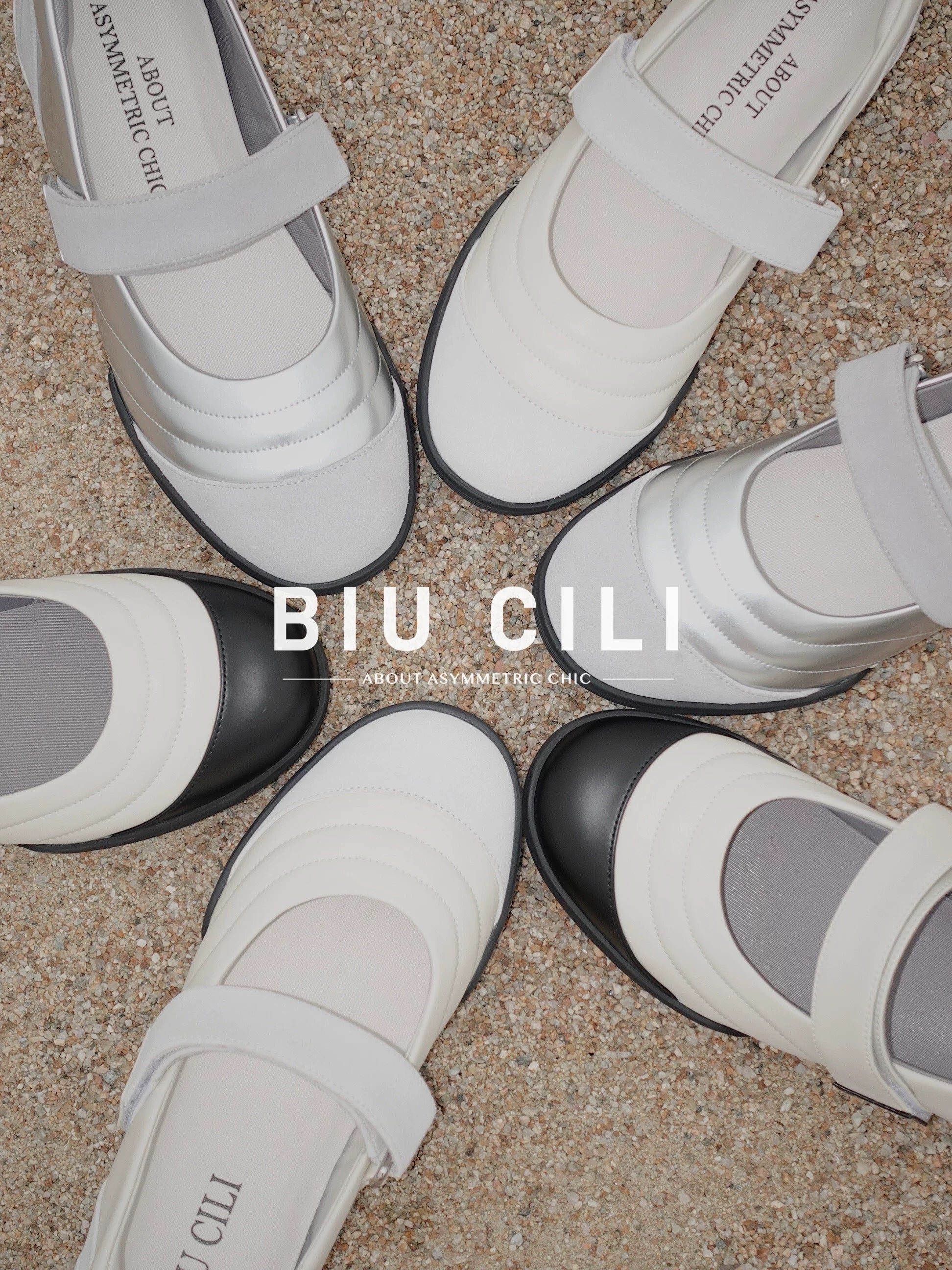 Overhead view of BIU CILI Mary Jane flats in multiple colorways arranged in a circle on sand, featuring brand logo and strap detail