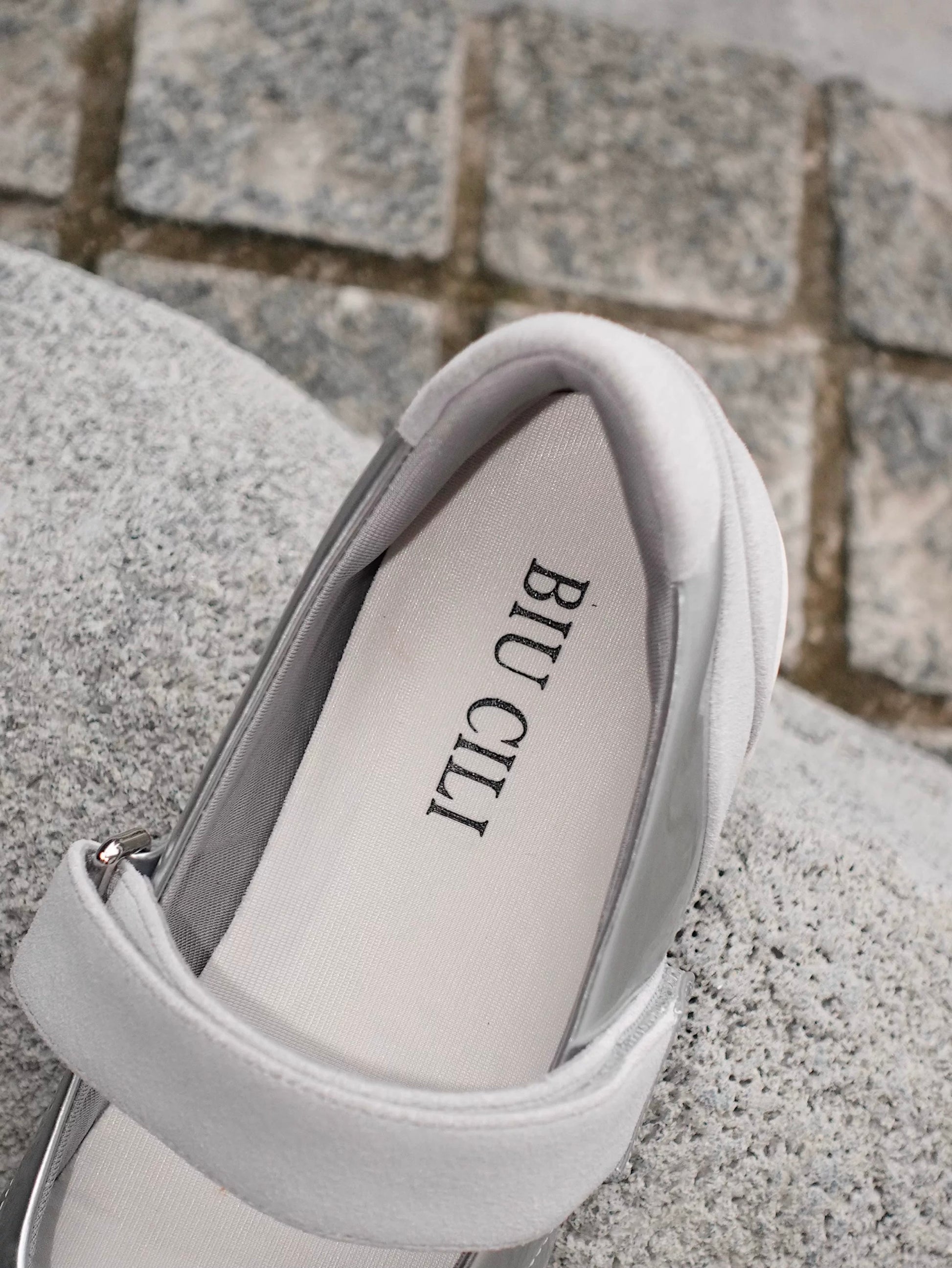 Close-up of the back of the Mary Jane flats in silver and white toe cap styles