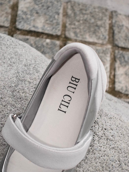Close-up of the back of the Mary Jane flats in silver and white toe cap styles