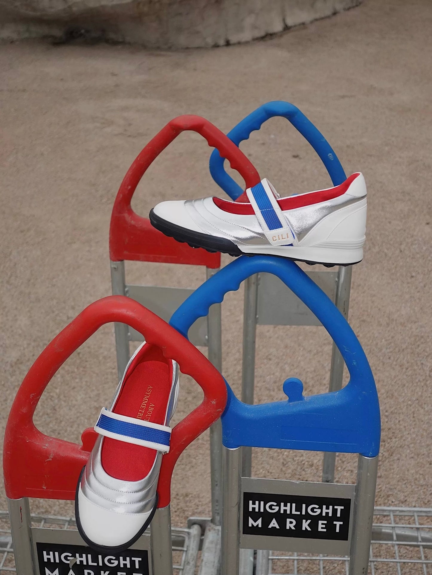 Kaia asymmetric Mary Jane flats in silver, white leather, red lining, with a blue strap, styled on colorful playground bars for a sporty-chic look