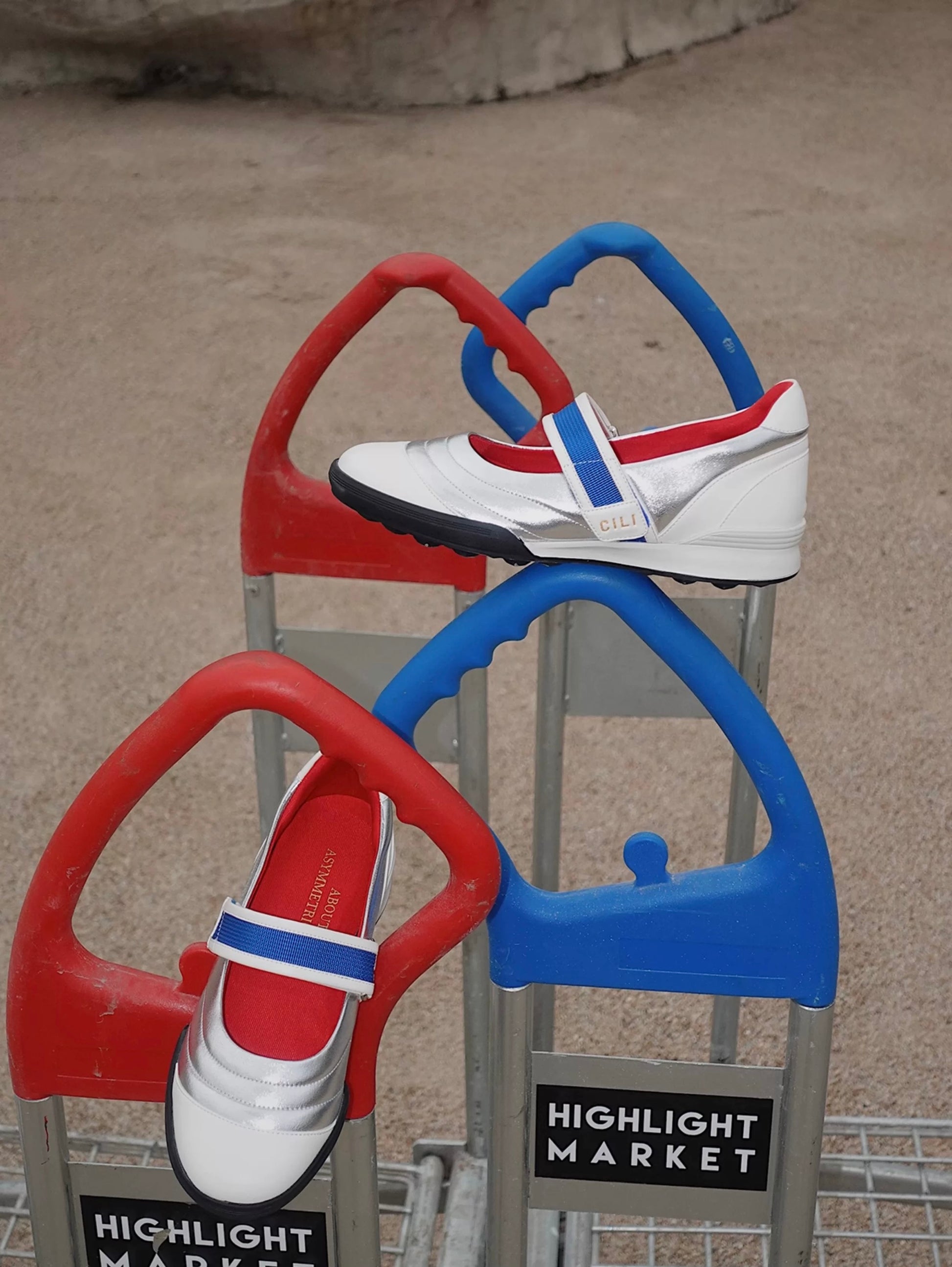 Kaia asymmetric Mary Jane flats in silver, white leather, red lining, with a blue strap, styled on colorful playground bars for a sporty-chic look