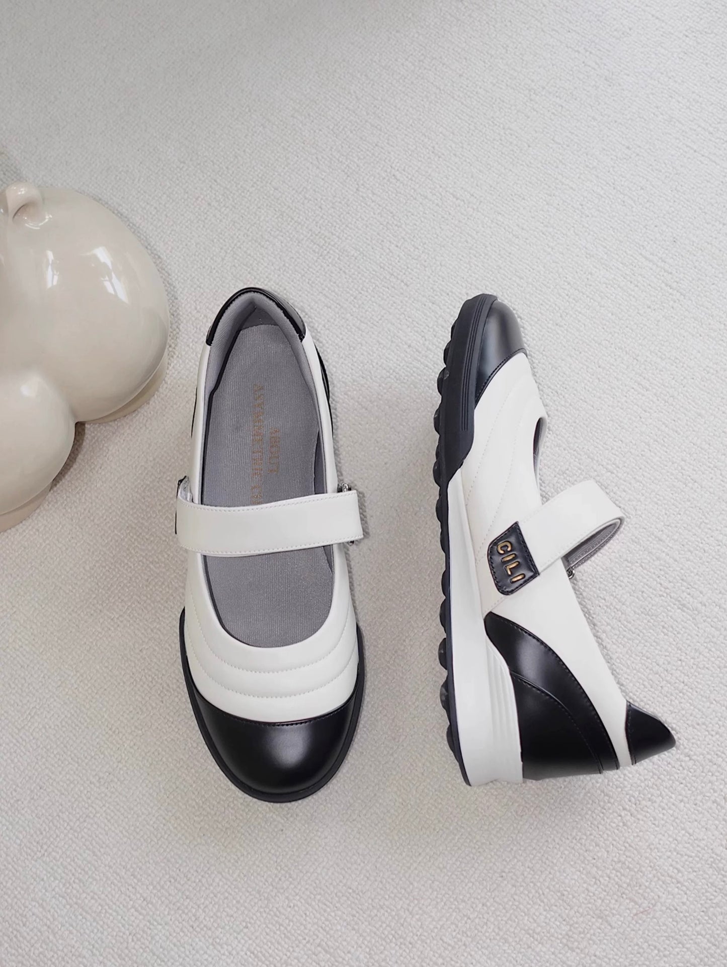 Close-up of Mary Jane flats in white and black toe cap styles