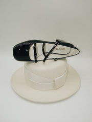 Black patent leather Mary Jane heels with triple straps, block heel, and bow detail.