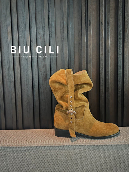Brown suede boot with decorative straps on a gray surface against a striped curtain background, featuring the brand 'BIU CILI'.