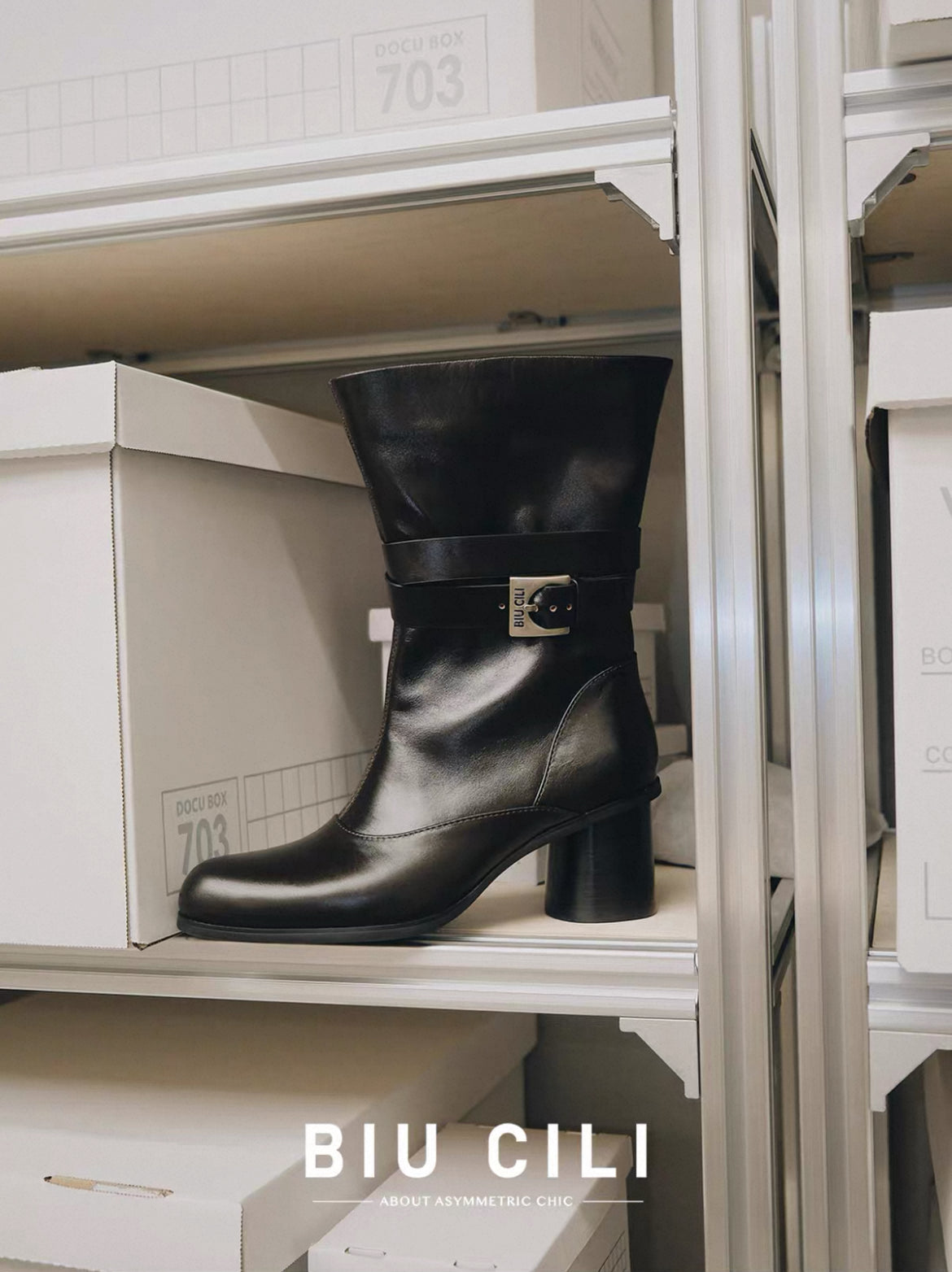 Black boot with a buckle on a shelf with 'BIU CILI' branding.