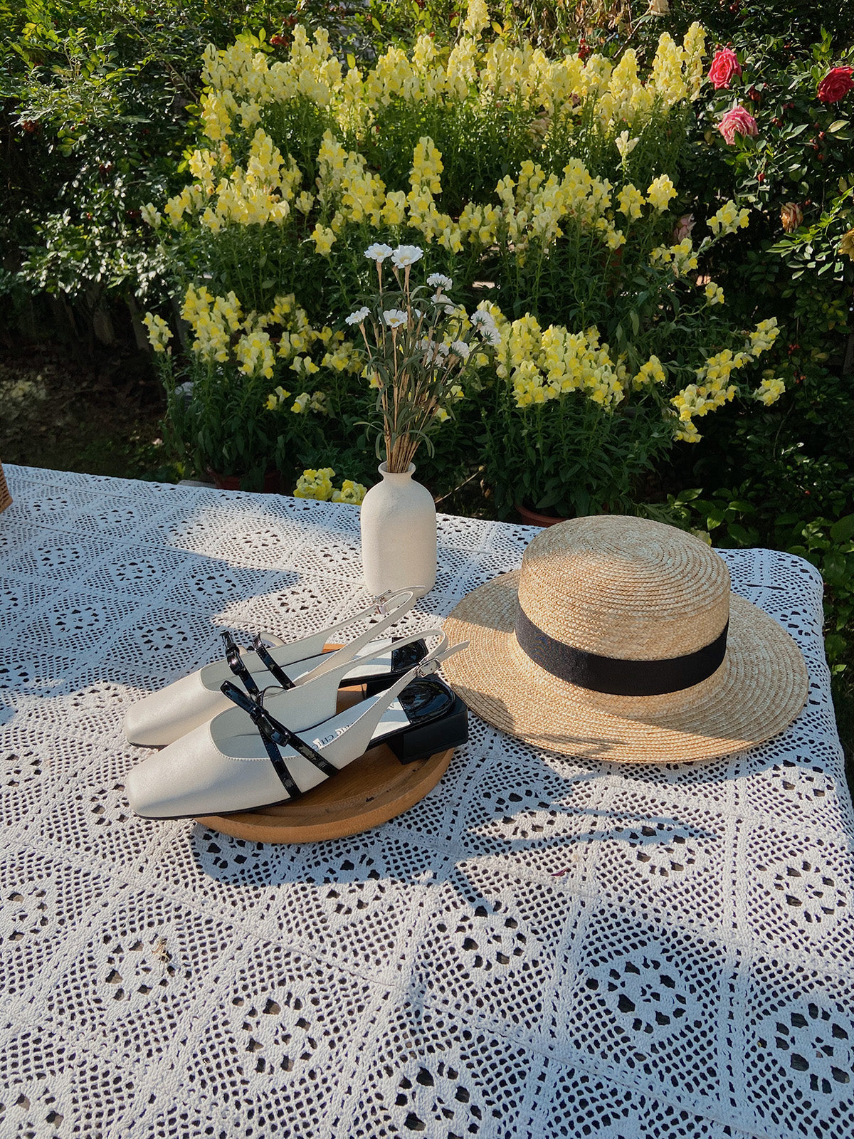 White Mary Jane shoes with square toe and black asymmetric bow straps, contrast heel, and soft leather finish.