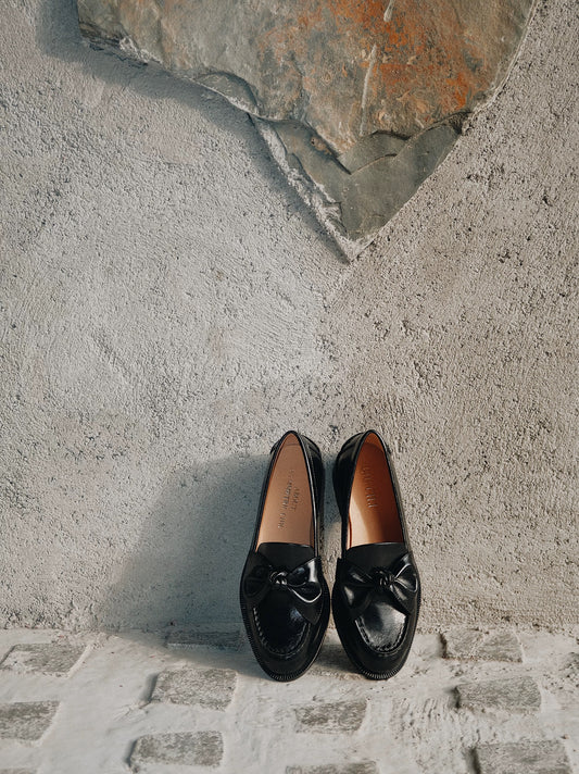 Pair of black loafers on a stone surface