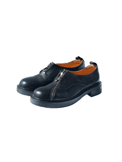 Black asymmetric leather loafers with curved zipper detail and rounded toe