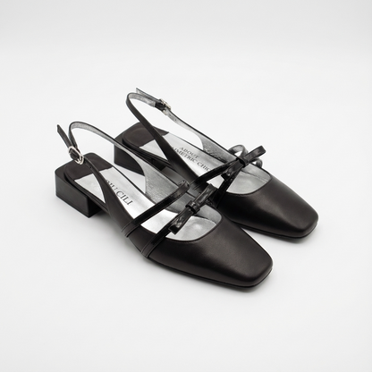 Black slingback shoes on a white background