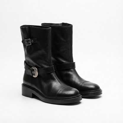 Pair of women's black leather boots with buckles on a white background
