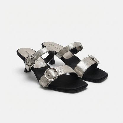 Pair of silver high-heeled sandals on a white background