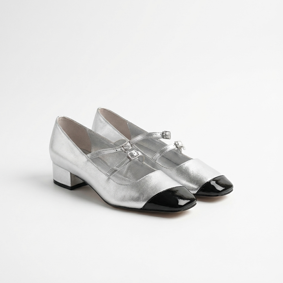 Pair of silver shoes with black toes on a white background