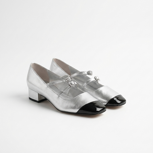 Pair of silver shoes with black toes on a white background